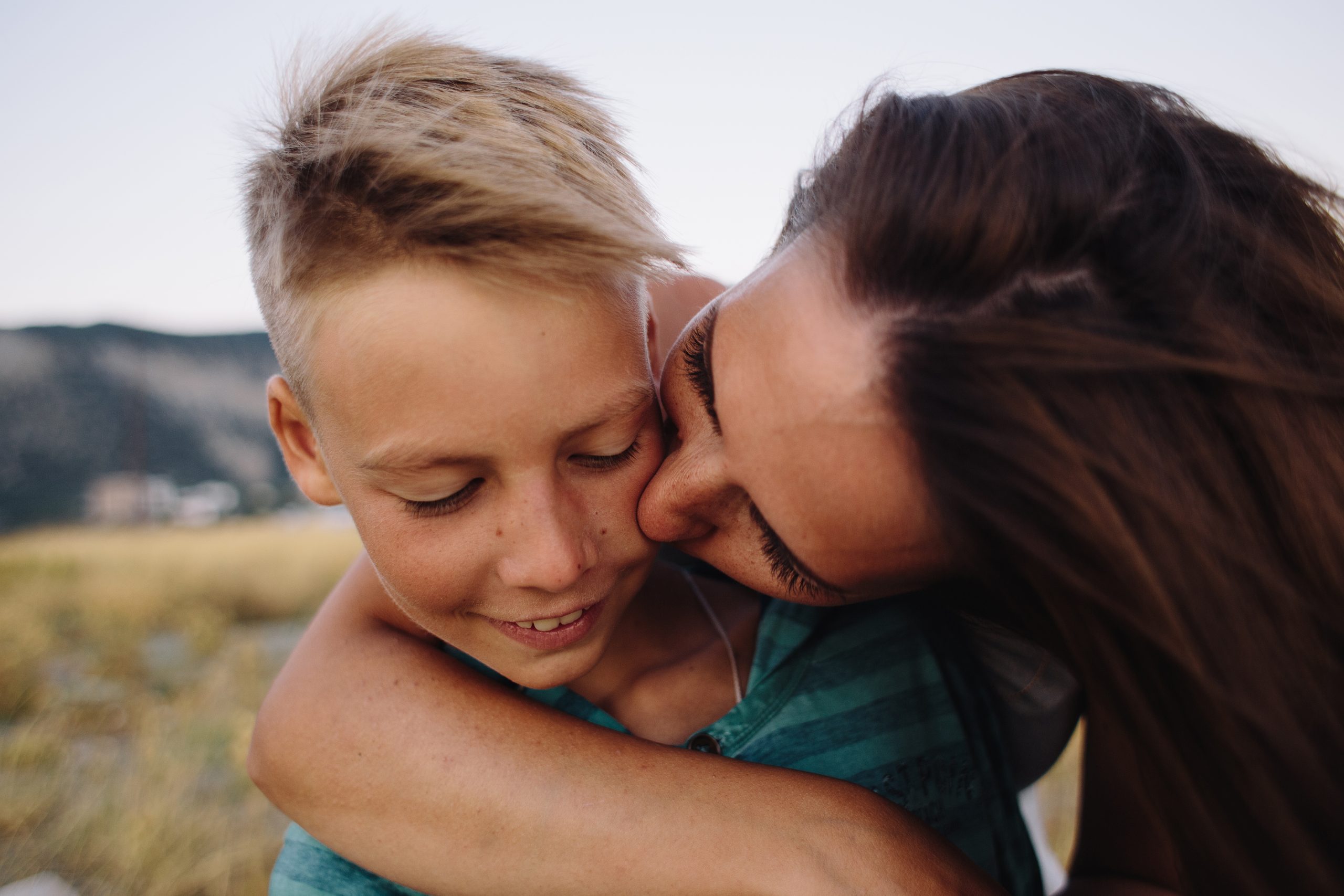 Portrait,Of,Woman,Kissing,Her,Smiling,Son.,Soft,Focus,On